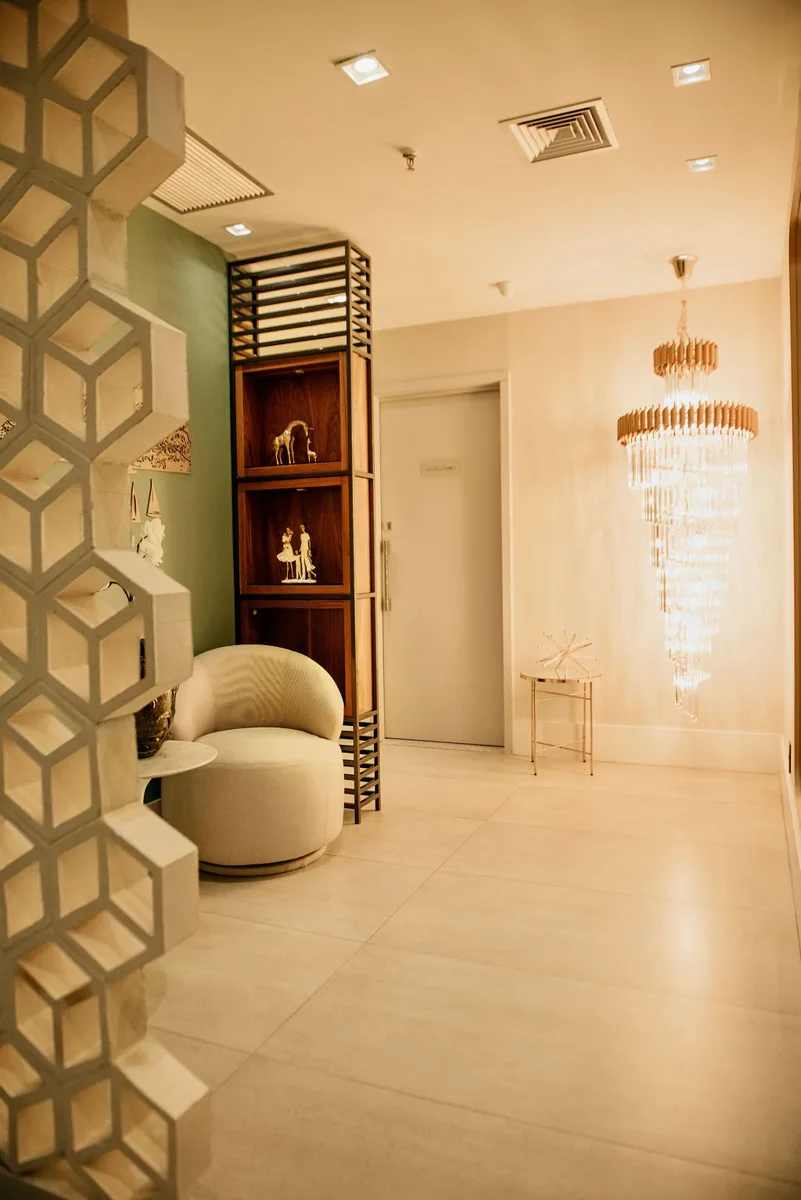 Recepção do Instituto Presenze com lustre de cristal, poltrona e divisória vazada